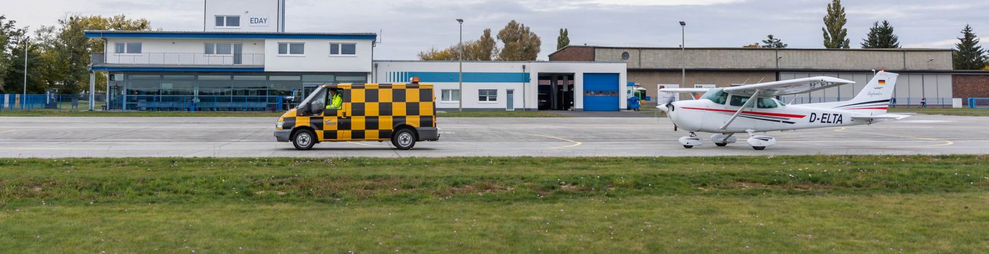 Ein Safety Car fährt vor einem Flugzeug