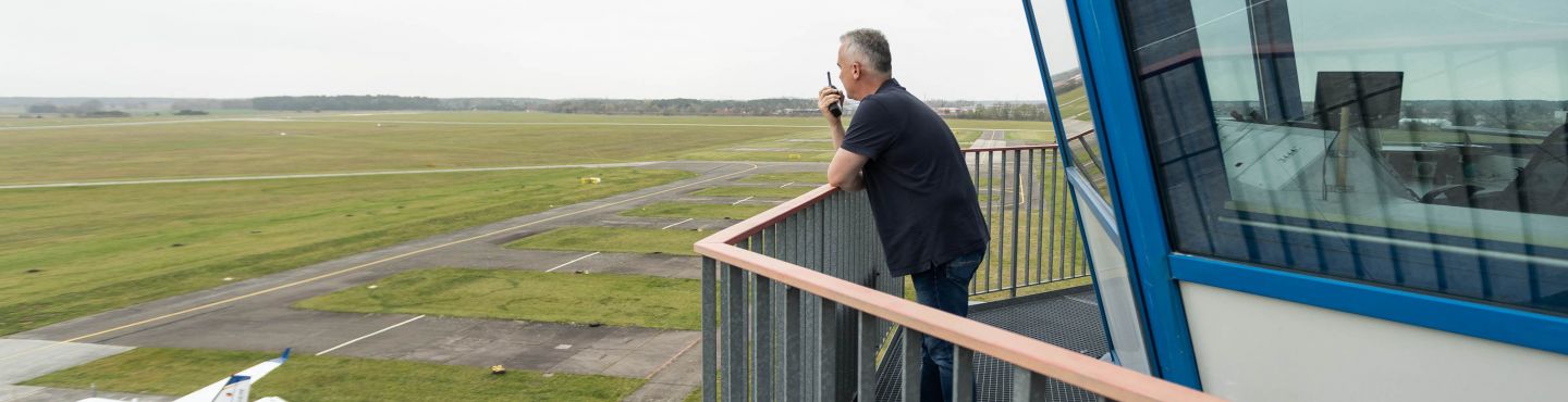 Eine Person steht auf dem Tower am Flugplatz