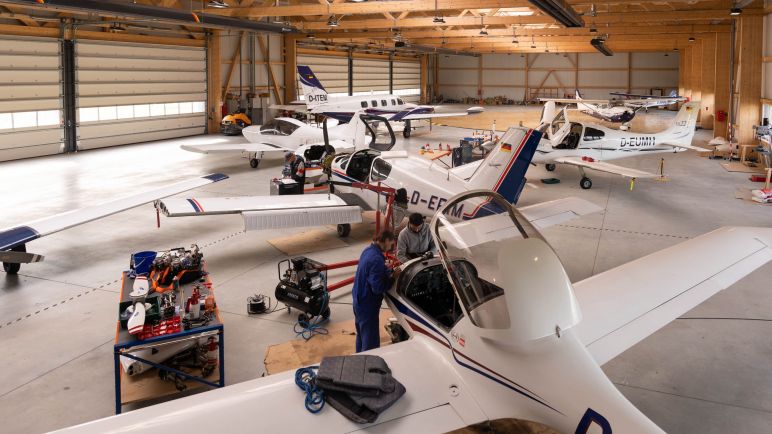 Zwei Personen reparieren einen Flieger